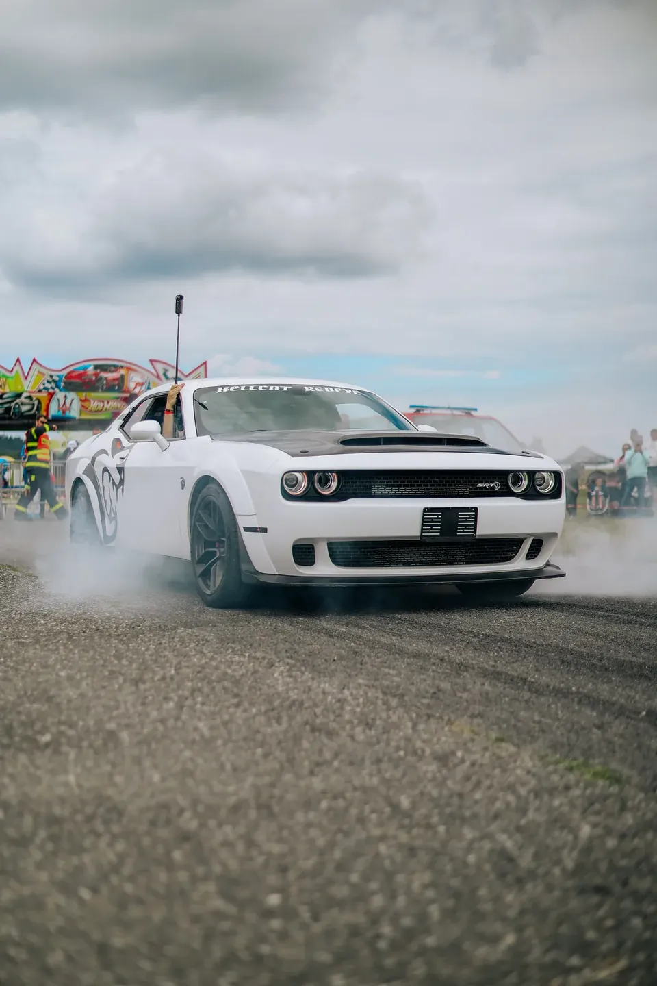 Bílý Dodge Challenger zepředu při burnoutu na dráze