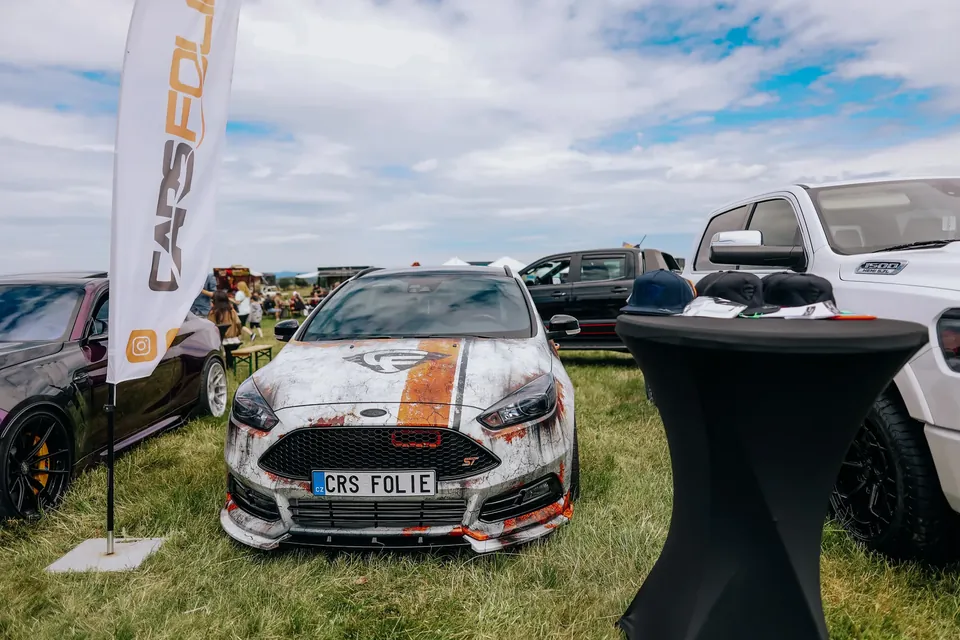 Ford Focus ST s polepem v rezavém stylu na výstavní ploše na trávě